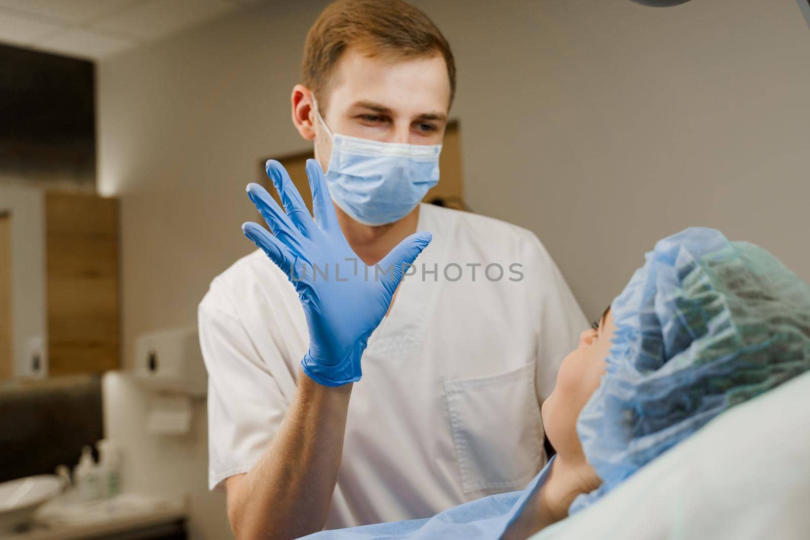 Doctor after lips augmentation looks at patient with happy emotion.