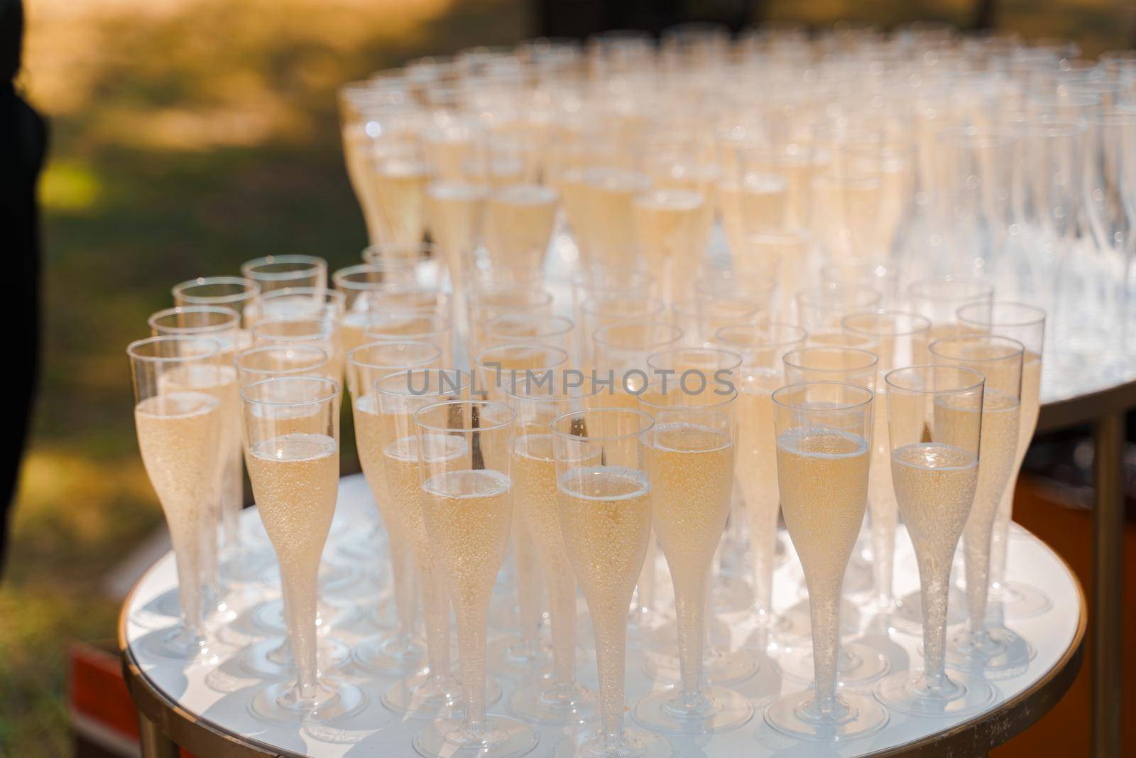 Aperitif champagne for business meeting conference participants. Welcome drink zone with champagne in disposable plastic wine cups.