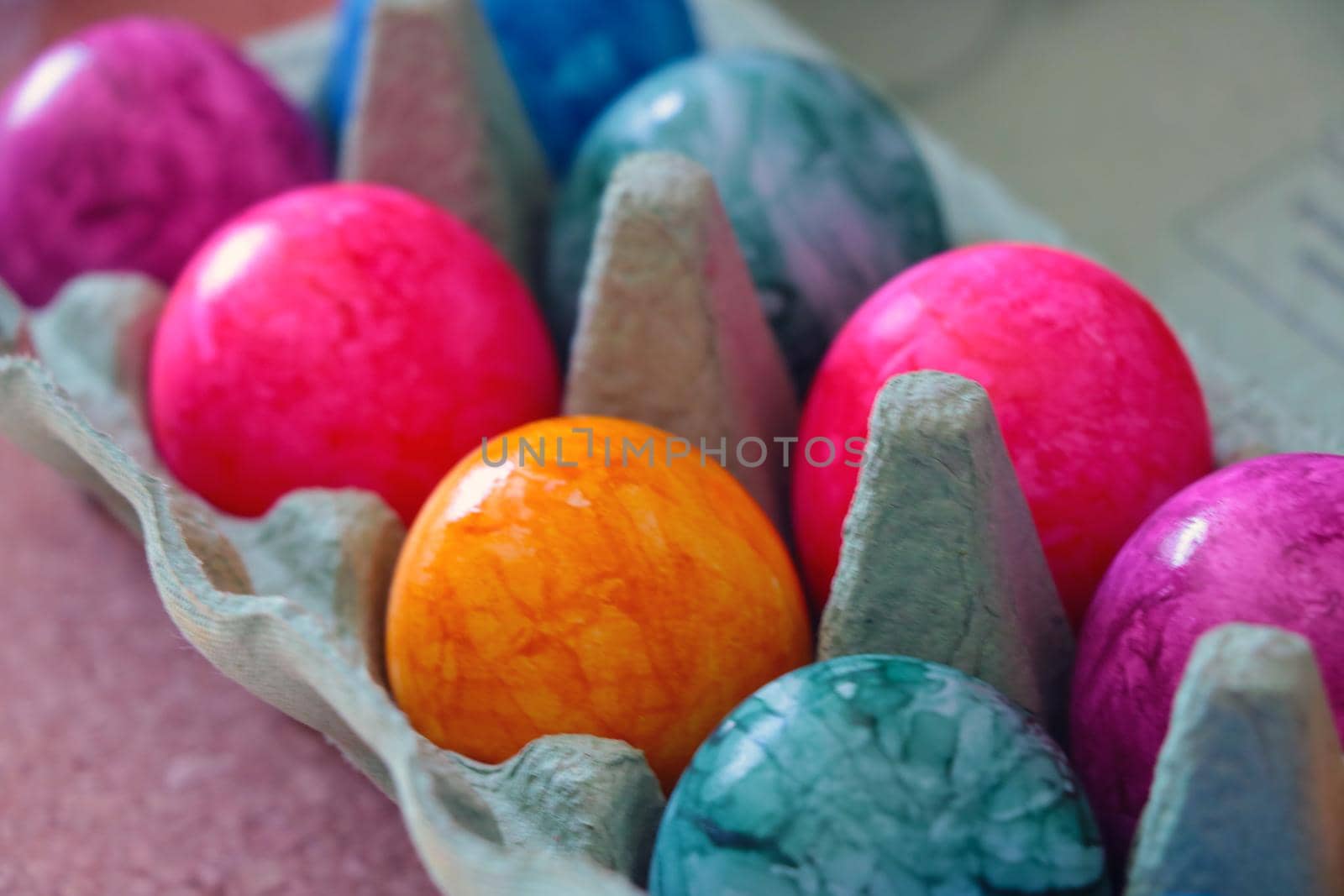 Colorful eggs in a cardboard box. Holiday. Out of focus