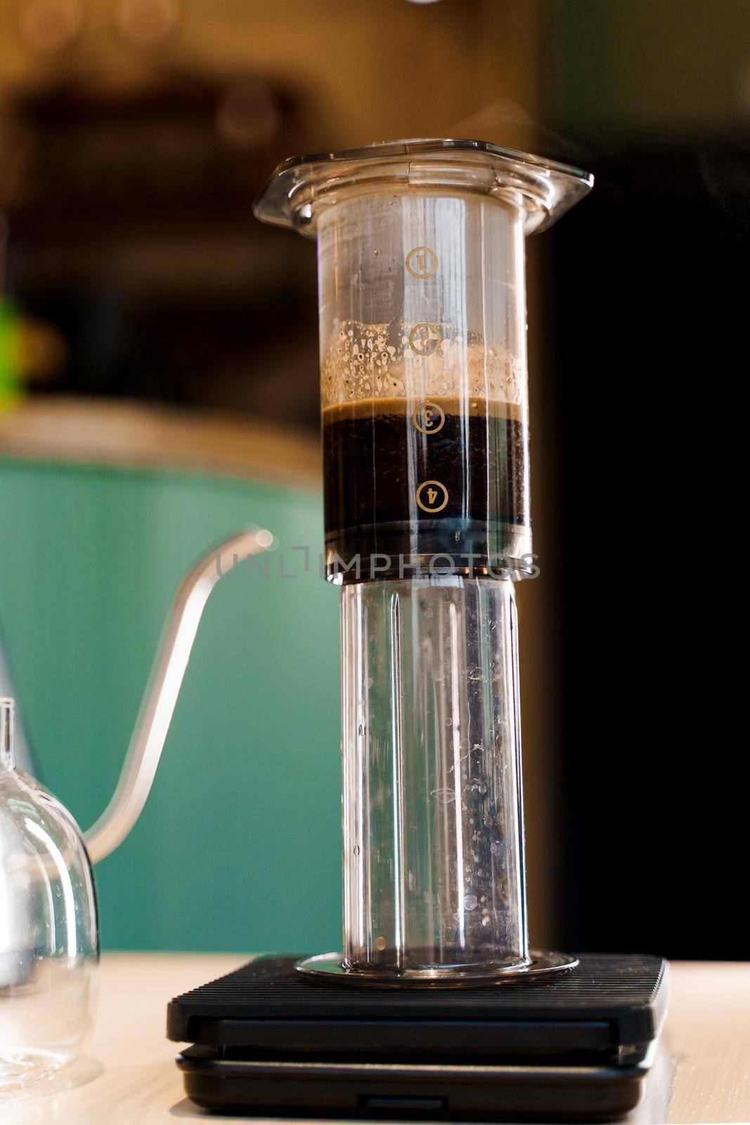 Coffee aeropress creams close-up on the scales. Alternative coffee brewing method. Aeropress device on the table.