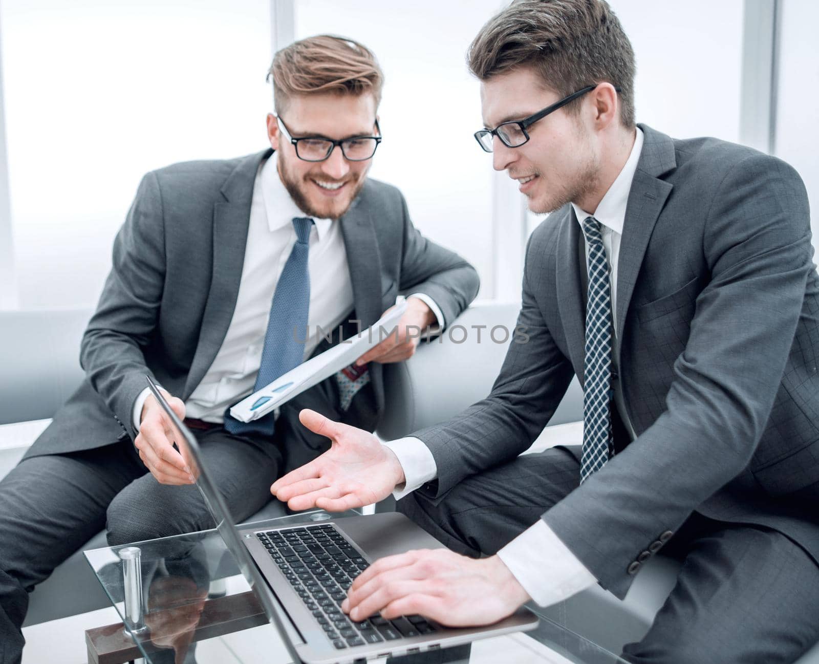 close up.business colleagues use a laptop to check financial data by asdf