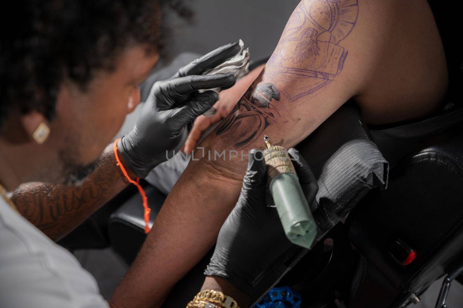 Cinematic shot of a Tattoo artist creating Body art at the tattoo studio by HERRAEZ