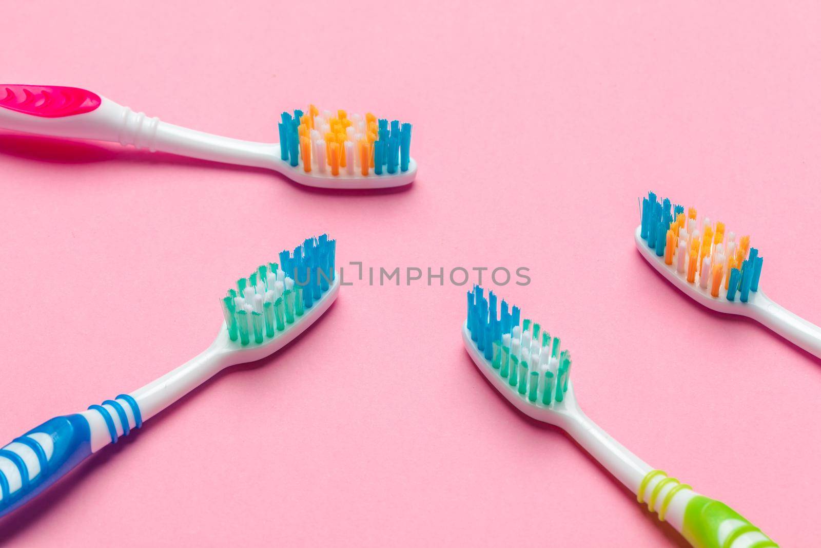 Toothbrushes on pink background. Macro photo. Close up. by Fabrikasimf