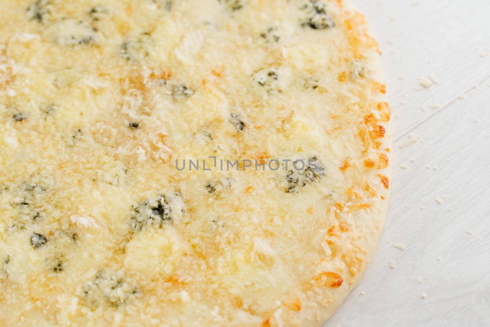 Pizza with cheese such as parmesan, hard cheese, dor blue and mozzarella isolated on white wooden background. Advert for social network of restaurants, caffee