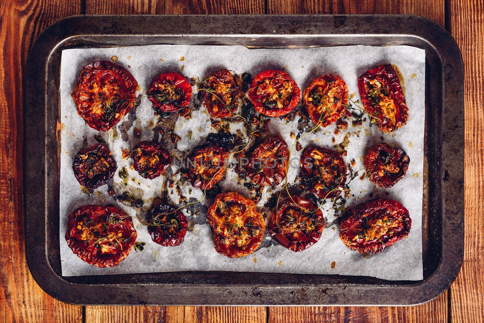 Baking Sheet Full of Freshly Cooked Sun Dried Tomatoes with Thyme and Olive Oil Ready for Preserving. View from Above.