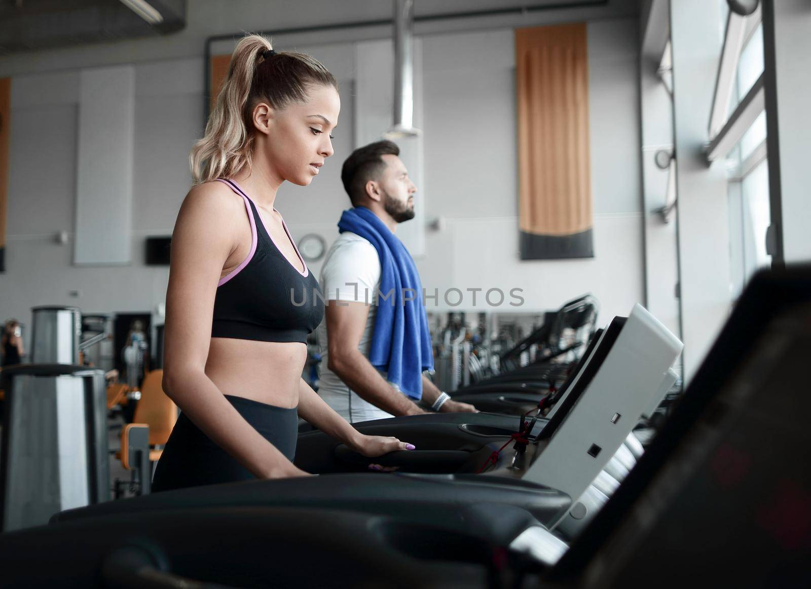 beautiful sports people work on the treadmill in the gym by asdf