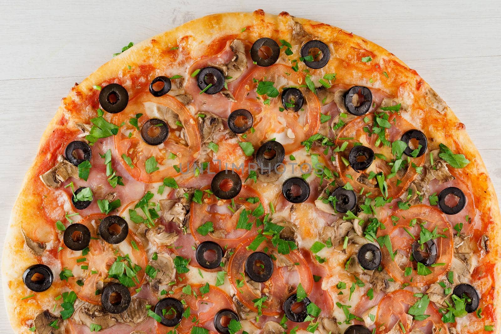 Pizza with meat, olives, tomatoes, mushrooms, herbs isolated on white wooden background. Advert for social network of restaurants, caffee. Promotion for pizzeria
