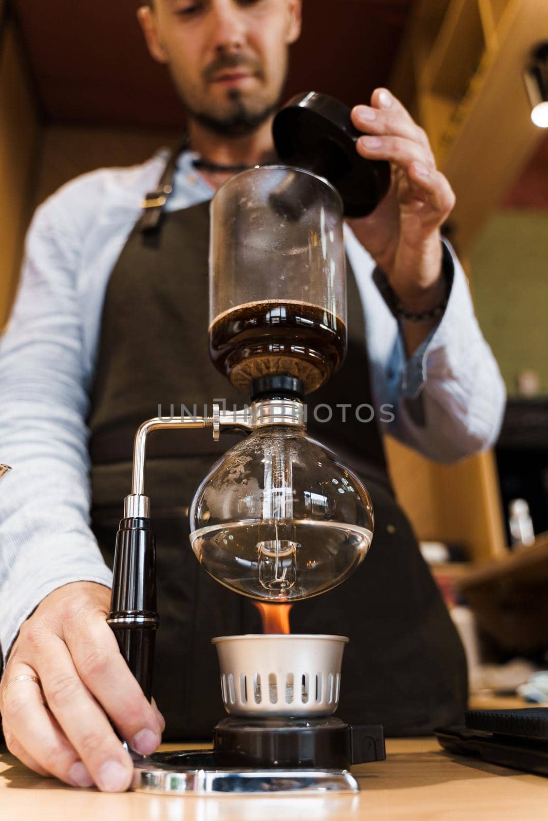 Syphon coffee brewing process. Close up syphon is heating by fire. Brewing photo on the fire. Alternative method of coffee making