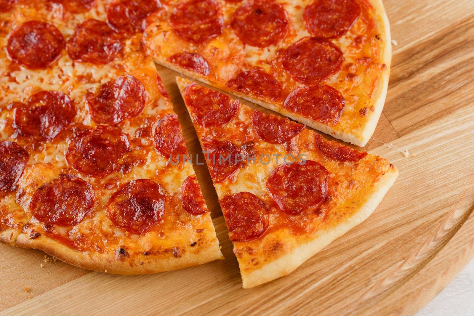 Piece of pizza close-up on the wooden desk. Advert for pezzeria caffee and restaurant. Food delivery at quarantine covid-19 concept.