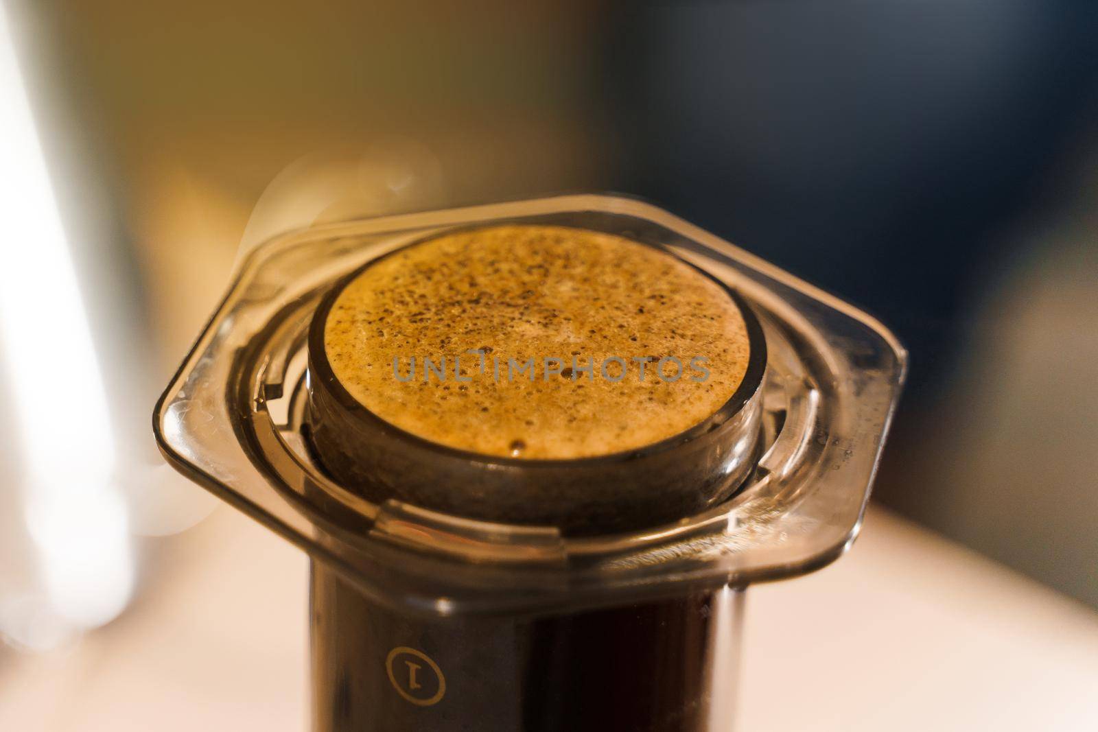 Coffee aeropress creams close-up. Alternative coffee brewing method. Aeropress device on the table. Advert for social networks of restaurants, cafe.