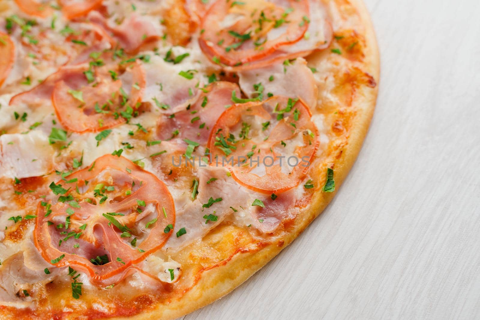 Pizza close-up on white wooden background. Food delivery for people who stay at home. Tasty fast food at quarantine coronavirus covid-19 period.
