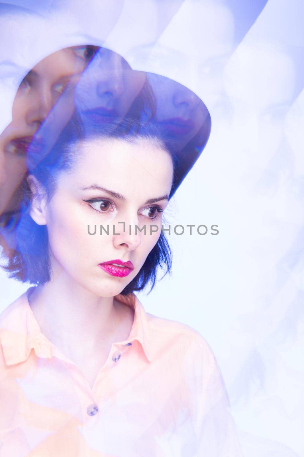 woman with pink lips in a hat on a blue background, art portrait. High quality photo