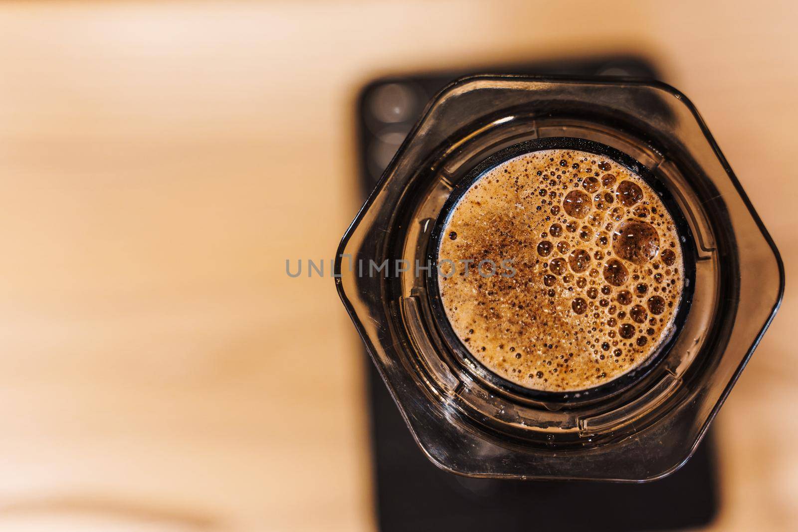 Coffee aeropress creams close-up. Alternative coffee brewing method. Aeropress device on the table. Advert for social networks of restaurants, cafe.