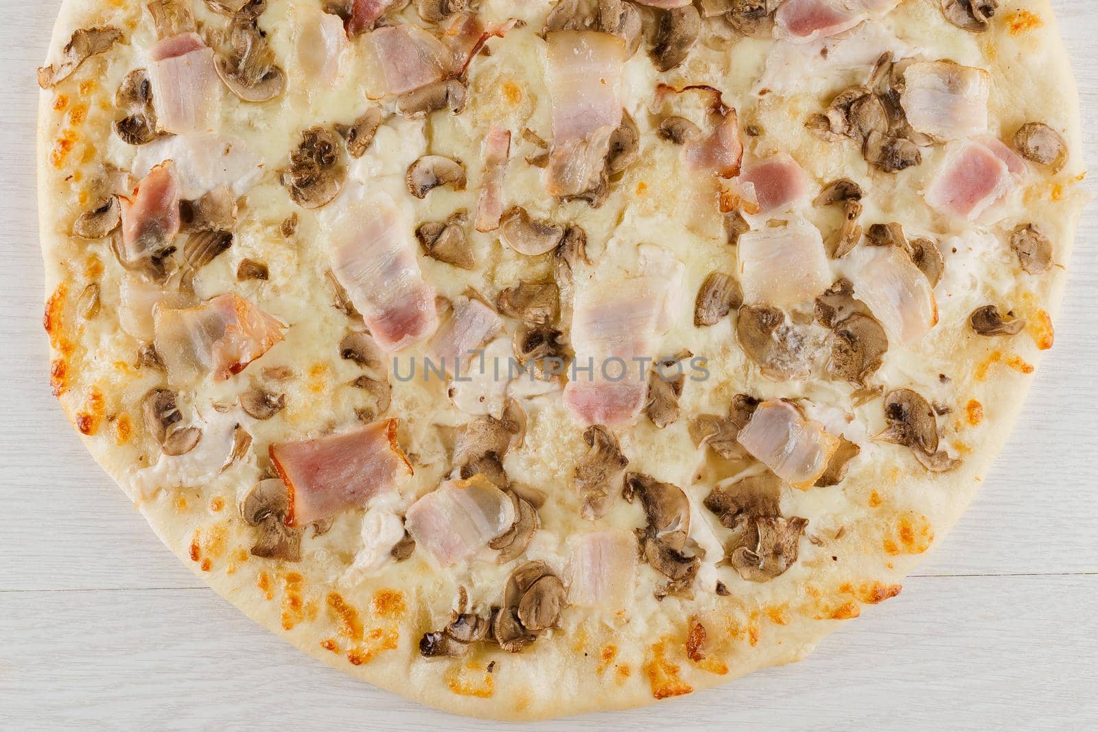 Pizza with bacon, mushrooms and cheese isolated on white wooden background. Advert for social network of restaurants, caffee. Promotion for pizzeria