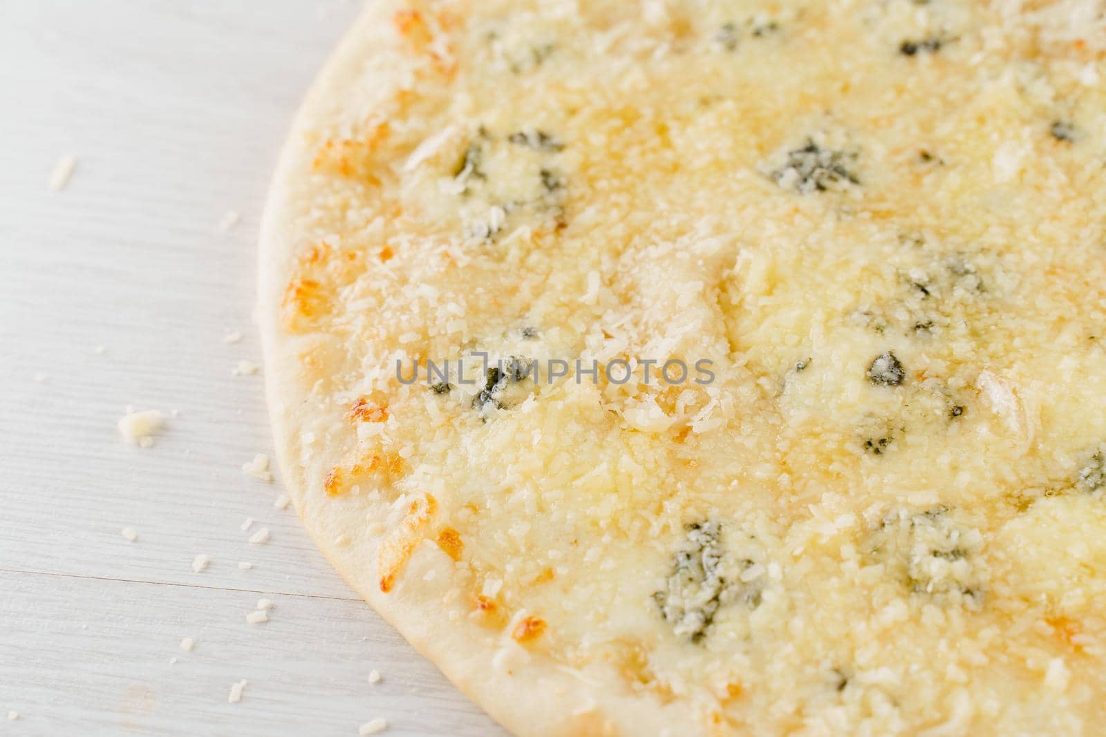 Pizza with cheese such as parmesan, hard cheese, dor blue and mozzarella isolated on white wooden background. Advert for social network of restaurants, caffee
