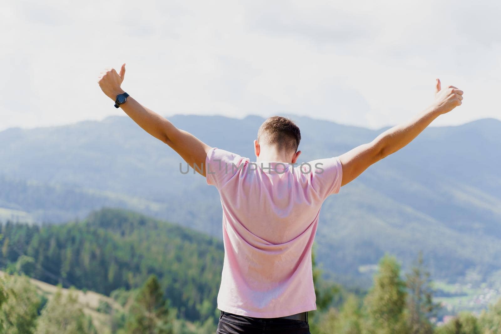 Tourism travelling in Ukraine. Man girl raised her hands up and enjoys the mountain hills view. Feeling freedom in Karpathian mountains.