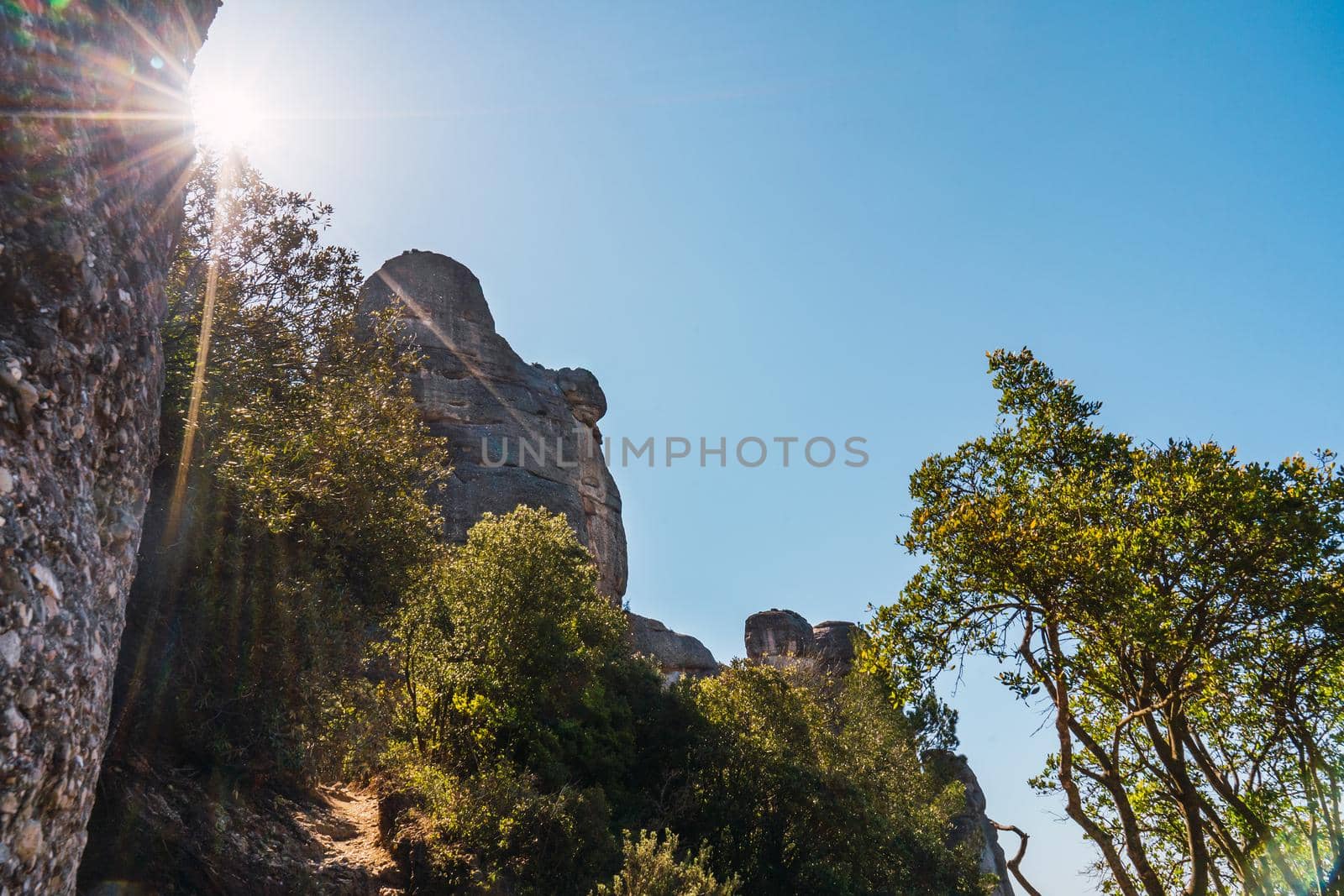 Mountain landscape, sunlit forest and blue sky. Mountain of Montserrat Spain. Mediterranean forest. warm weather, spring or summer season. holiday resort.