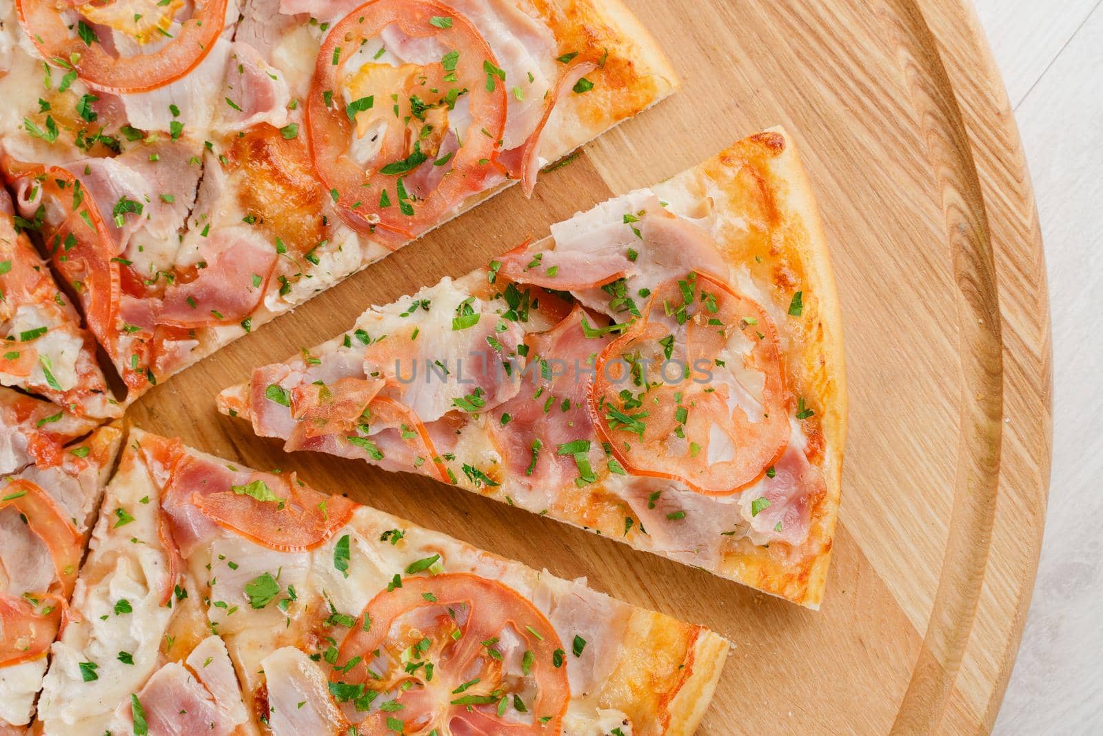 Piece of pizza close-up on the wooden desk. Advert for pizzeria caffee and restaurant. Food delivery at quarantine covid-19 concept.