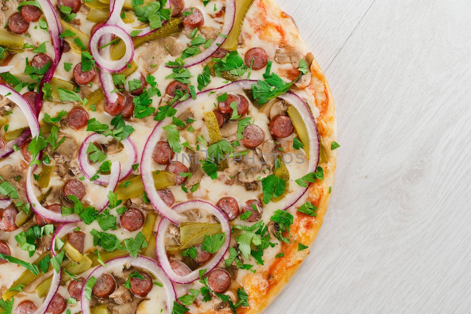 pizza with sausages, cucumber, pepper, cheese, onion isolated on white wooden background. Advert for social network of restaurants, caffee. Promotion for pizzeria
