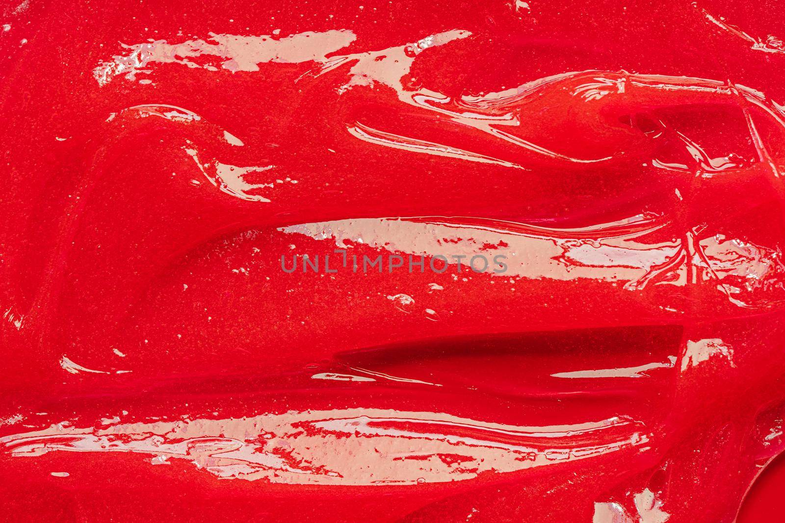 Red gel texture. Cosmetic clear liquid cream smudge. Skin care product sample closeup. Toothpaste or wax by photolime