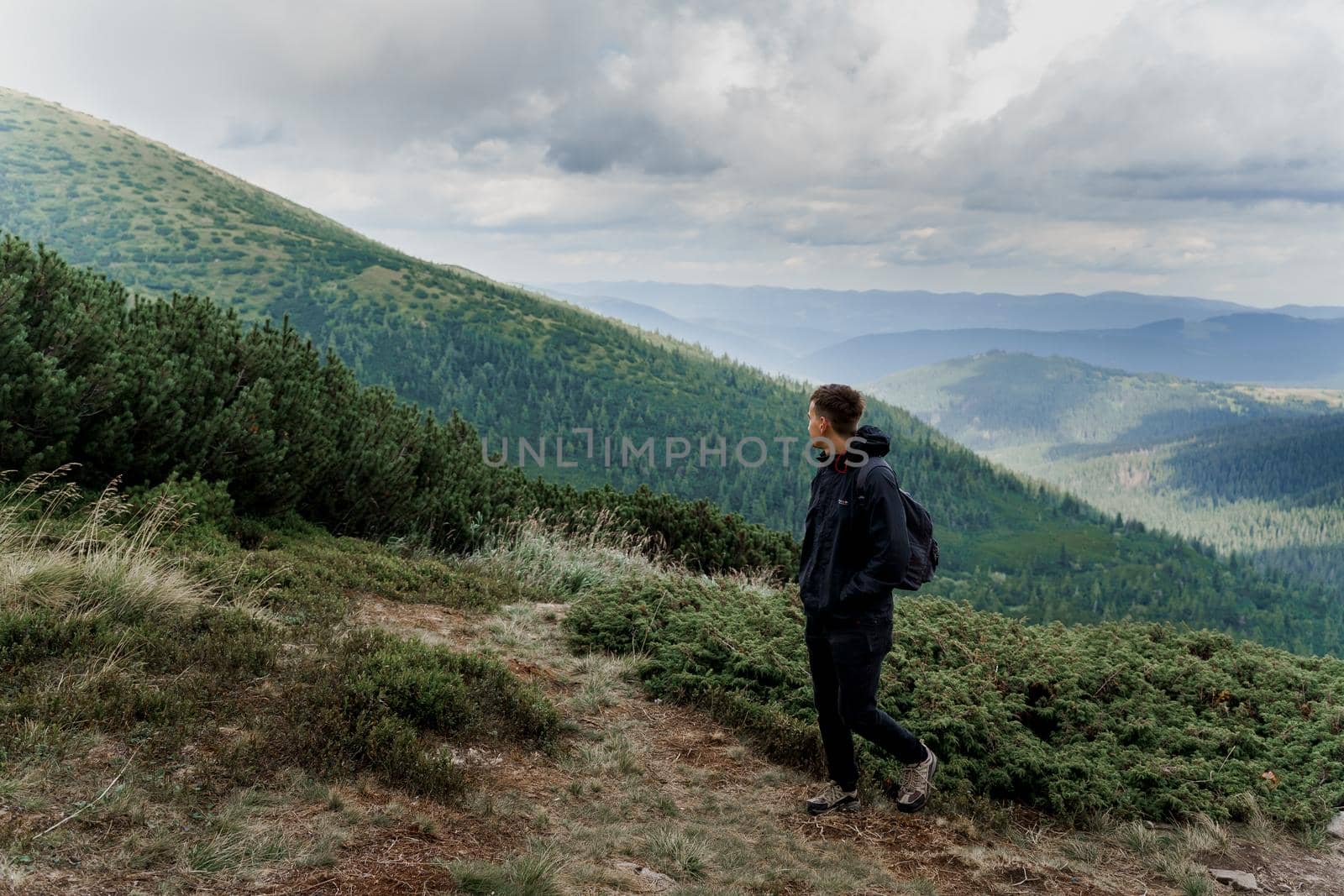 Hiking and climbing up to the top of the mountain. Men tourist is travelling and standing at the root of the mountain and watching to the peak by Rabizo