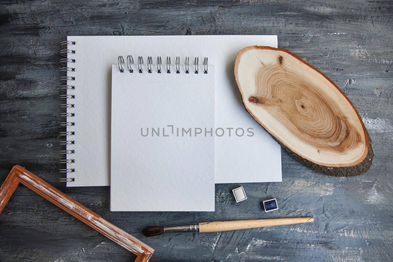 Artistic notepads with empty pages on black wood table background for portfolio design