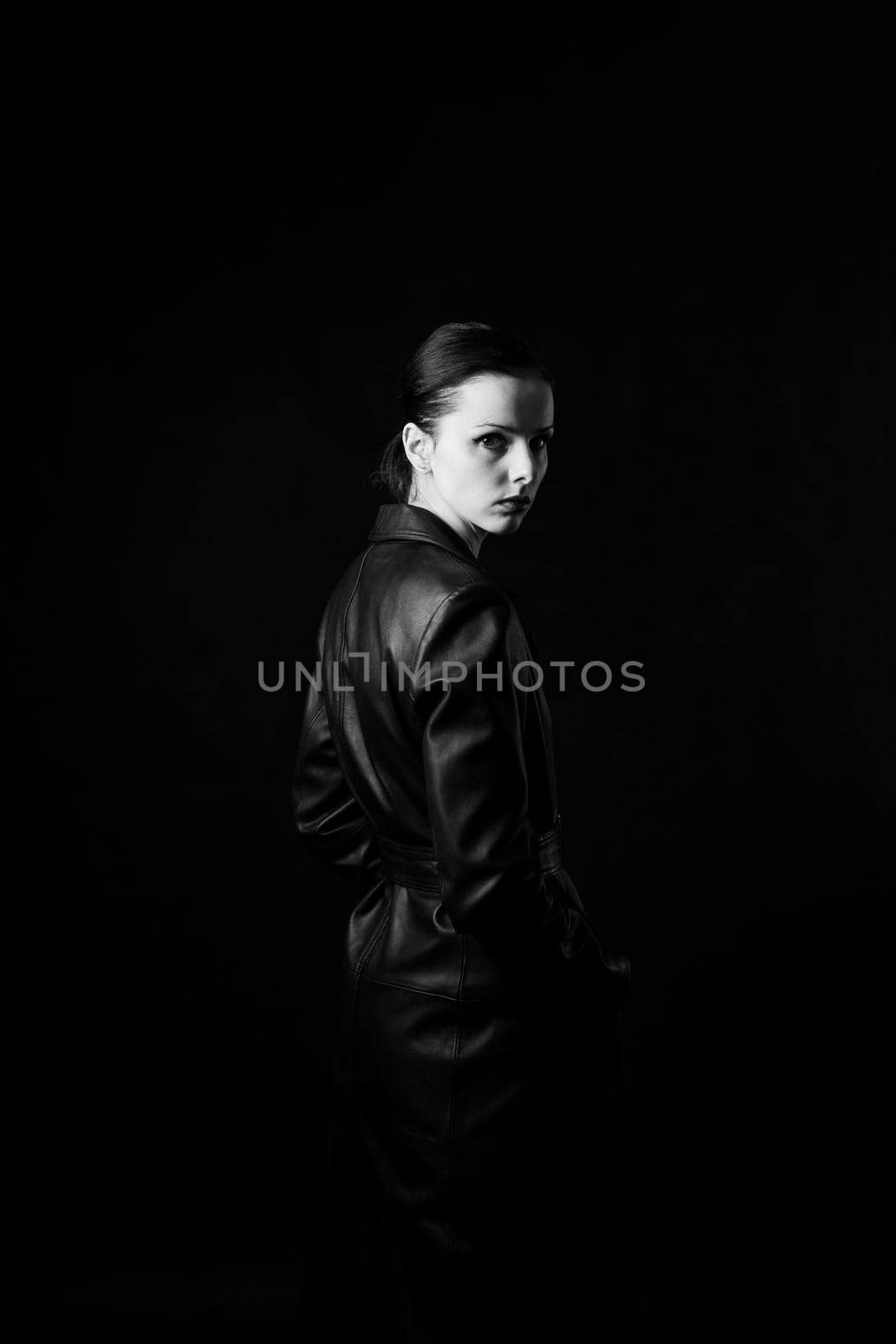 woman with closed eyes in leather coat and, black background. High quality photo