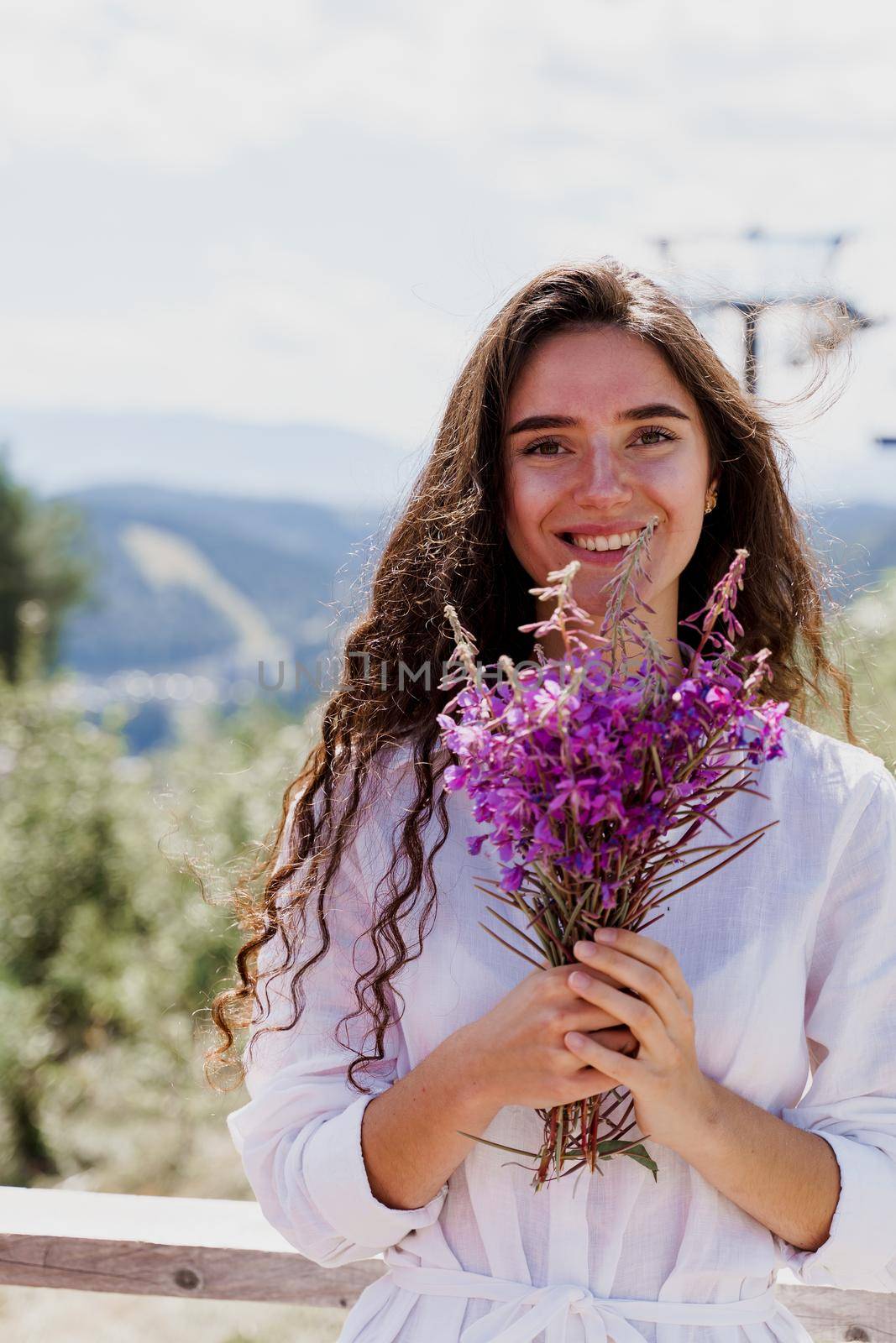 Smiling girl with flowers. Portrait of girl with bouquet in the forest. Tourism