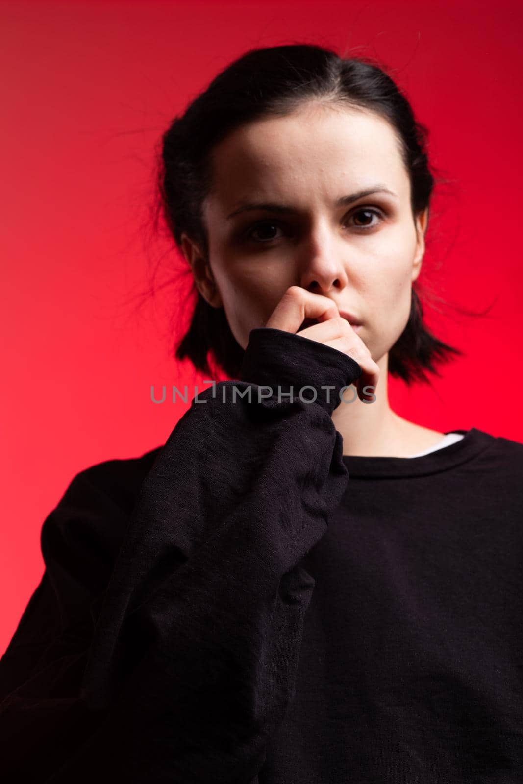 brunette woman in black clothes on red background by shilovskaya