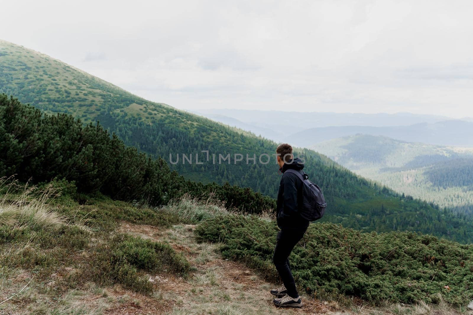 Hiking and climbing up to the top of the mountain. Men tourist is travelling and standing at the root of the mountain and watching to the peak by Rabizo