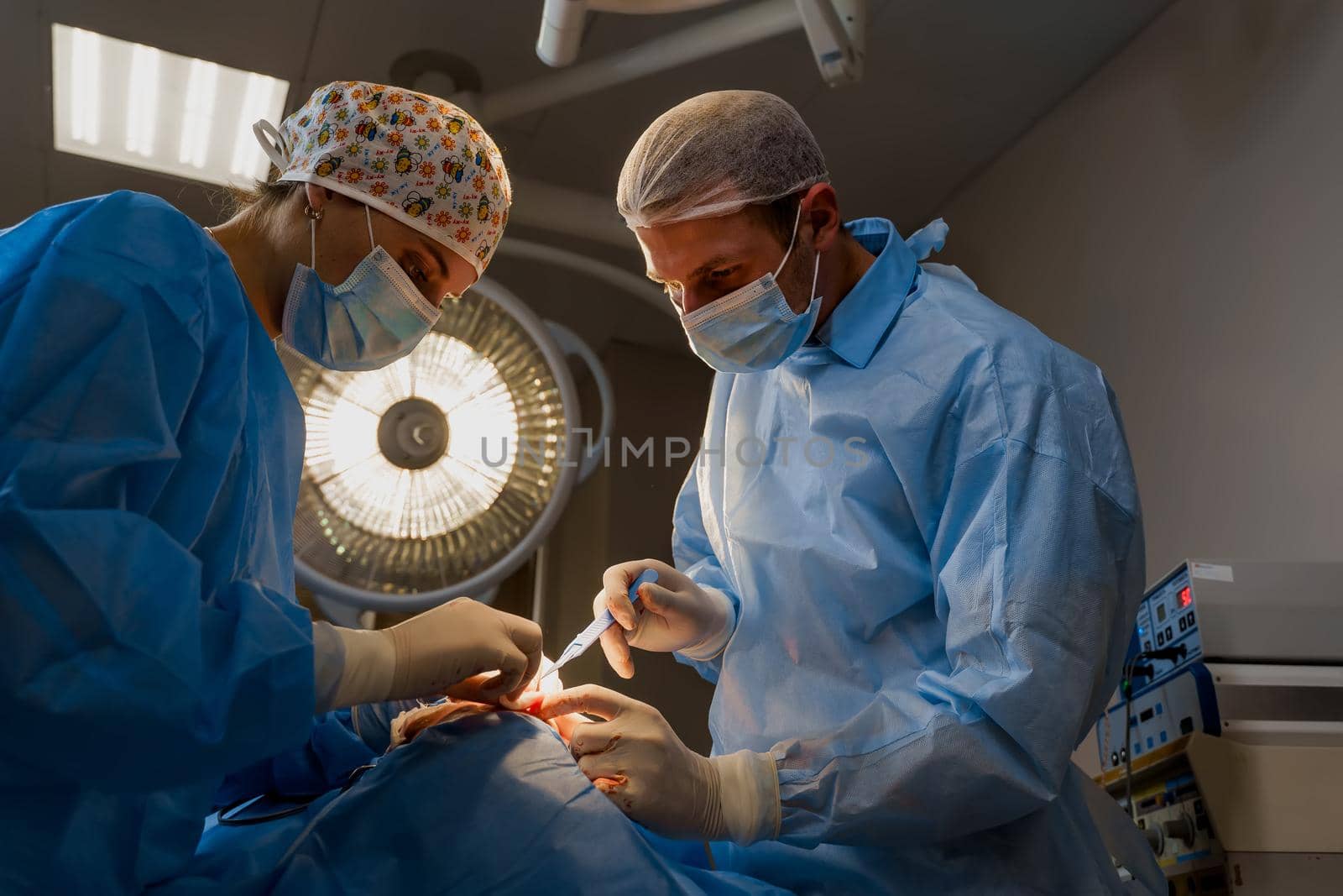 Lipofilling surgery operation. 2 surgeon do plastic surgery named blepharoplasty in medical clinic. Surgeon makes an incision with a surgical knife. by Rabizo