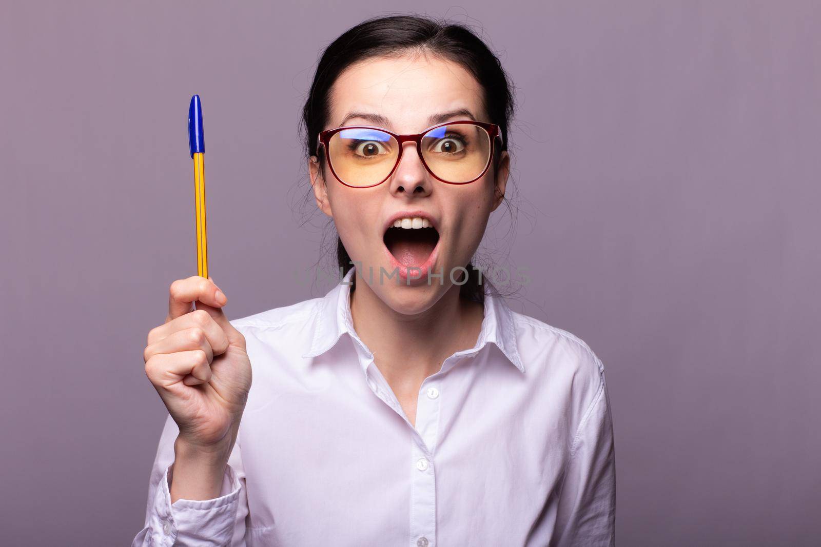woman in a white shirt and glasses holds a pen . High quality photo