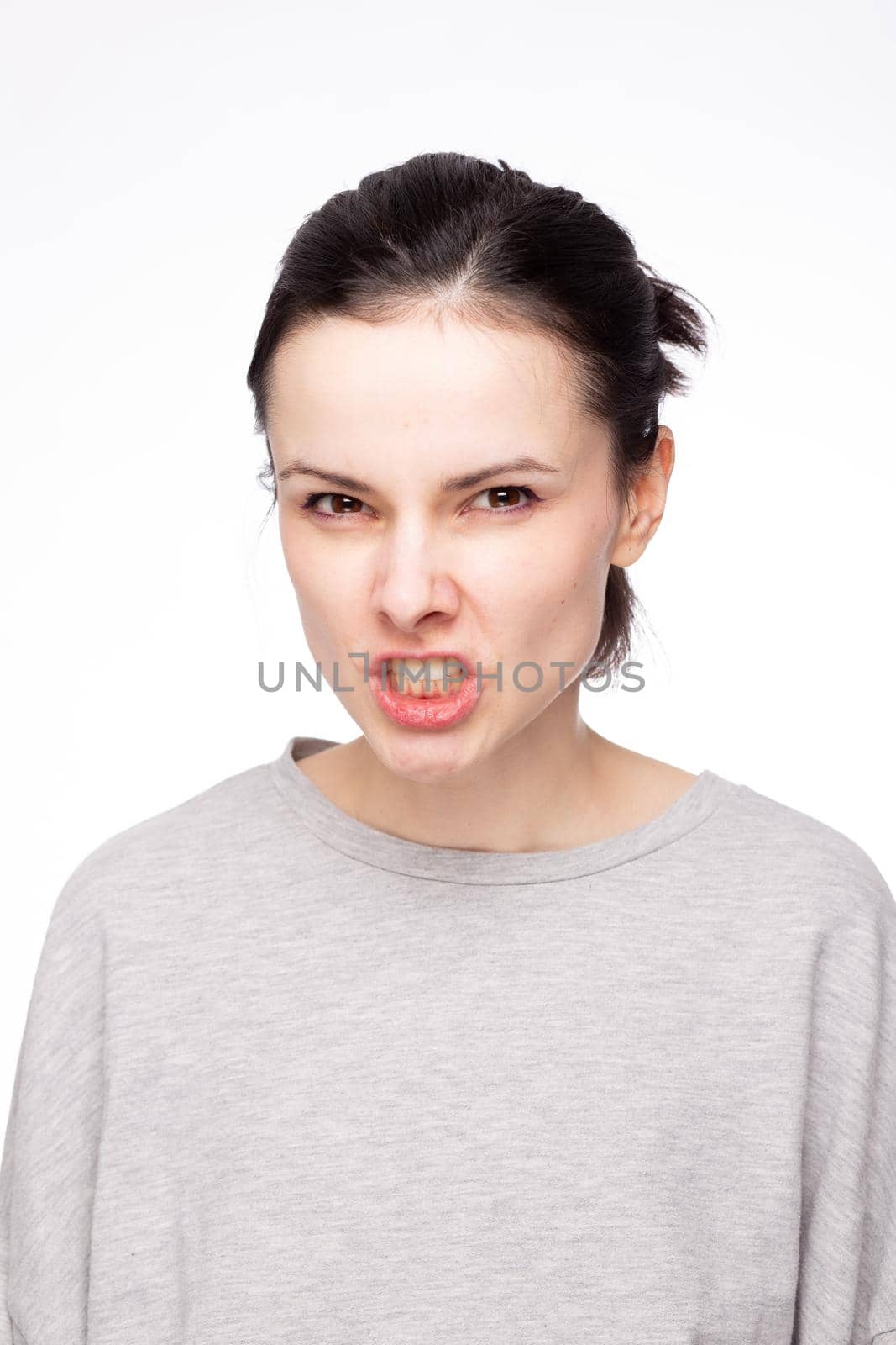 emotional woman in a gray sweatshirt, white background. High quality photo