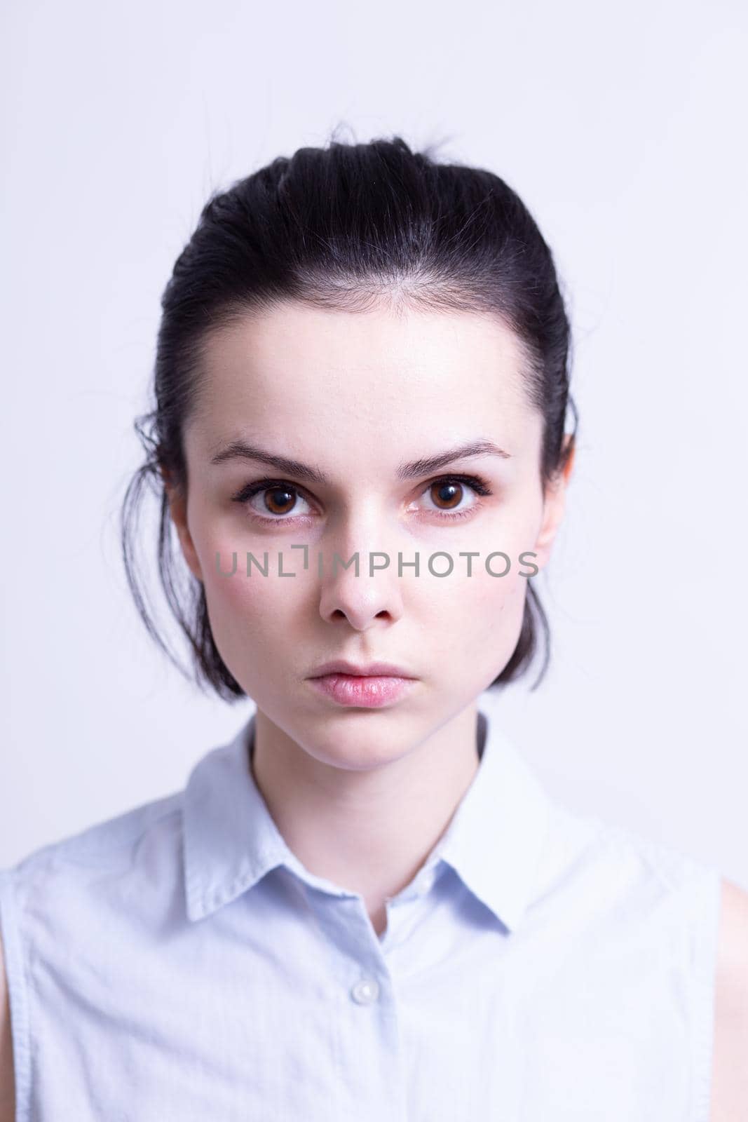 woman in a blue sleeveless office shirt, light background by shilovskaya