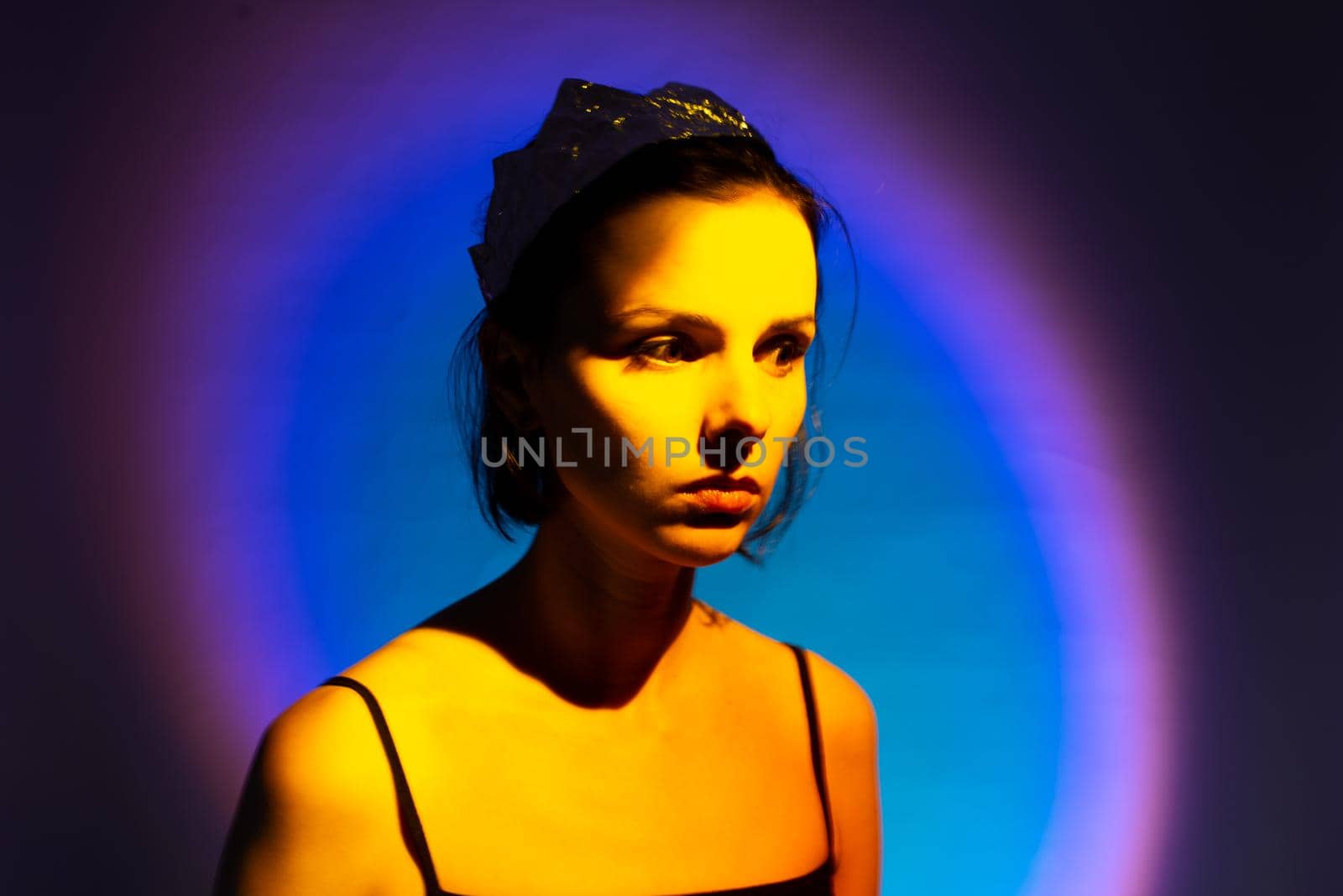 woman with a crown on her head in yellow light, art portrait. High quality photo