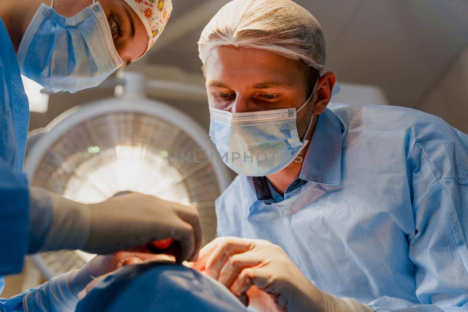 Blepharoplasty plastic surgery operation for modifying the eye region of the face in medical clinic. Surgeon sutures the eyelid.