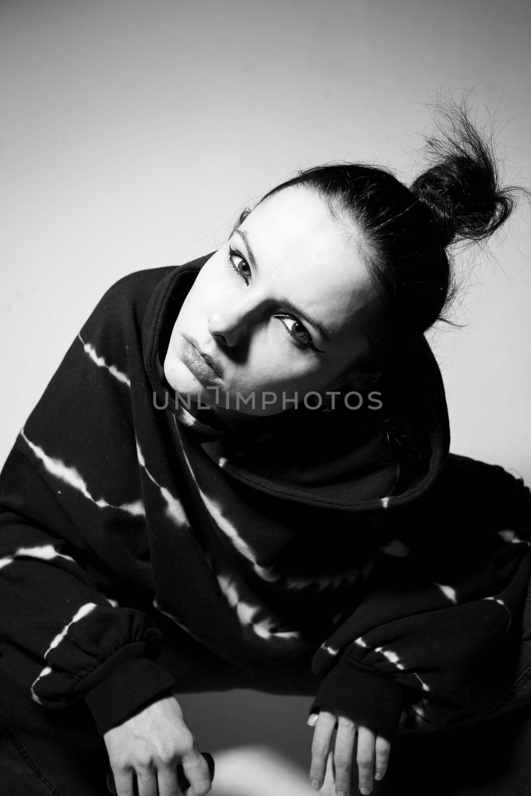 beautiful brunette girl in a black hoodie, light background by shilovskaya