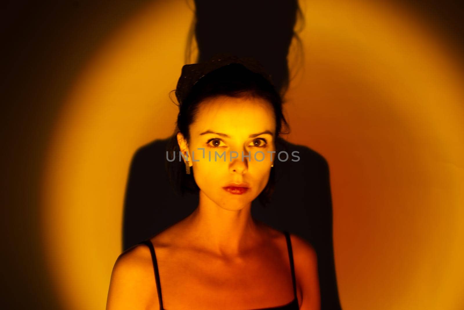 woman with a crown on her head in yellow light, art portrait by shilovskaya