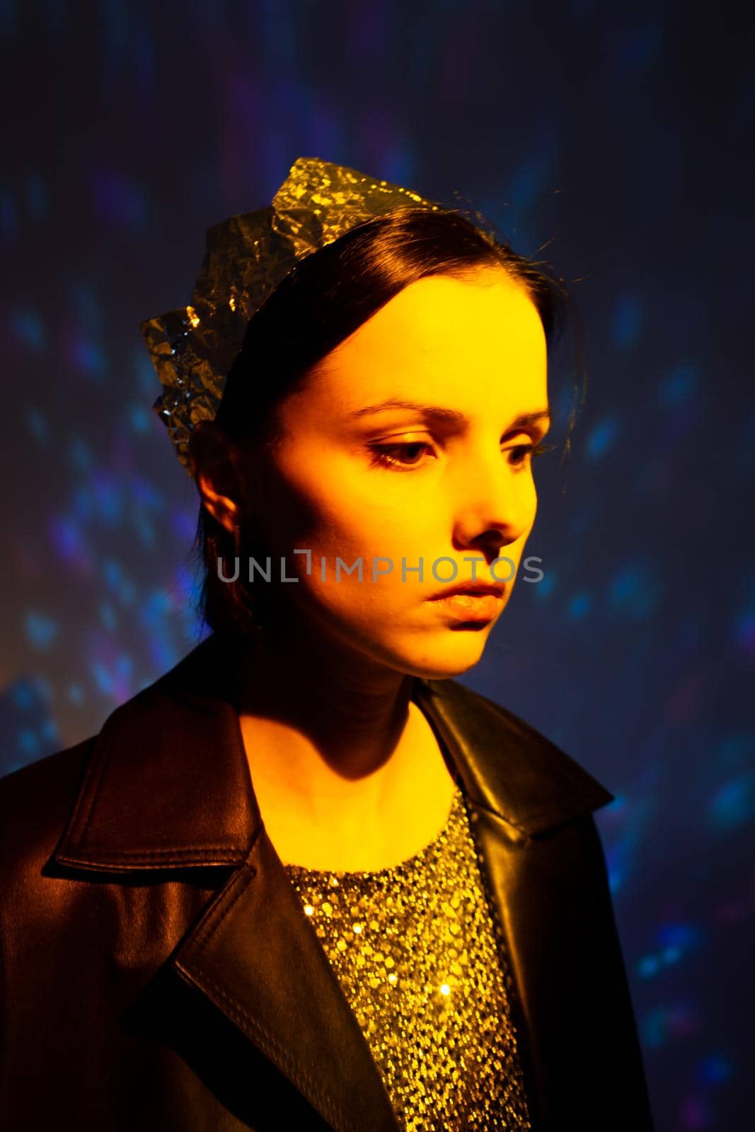 woman with a crown on her head in yellow light, art portrait. High quality photo