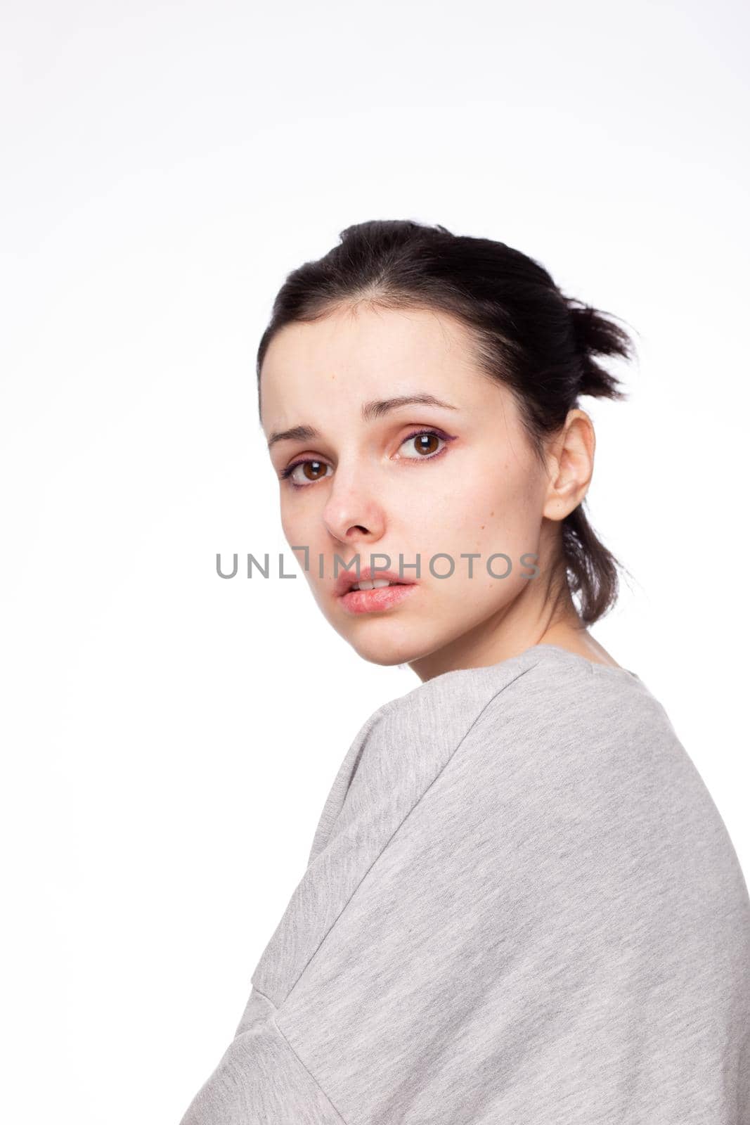 emotional woman in a gray sweatshirt, white background. High quality photo
