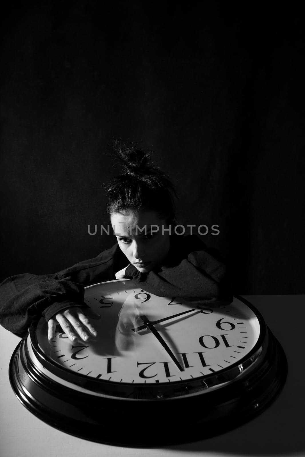 sad woman with big clock, black background by shilovskaya