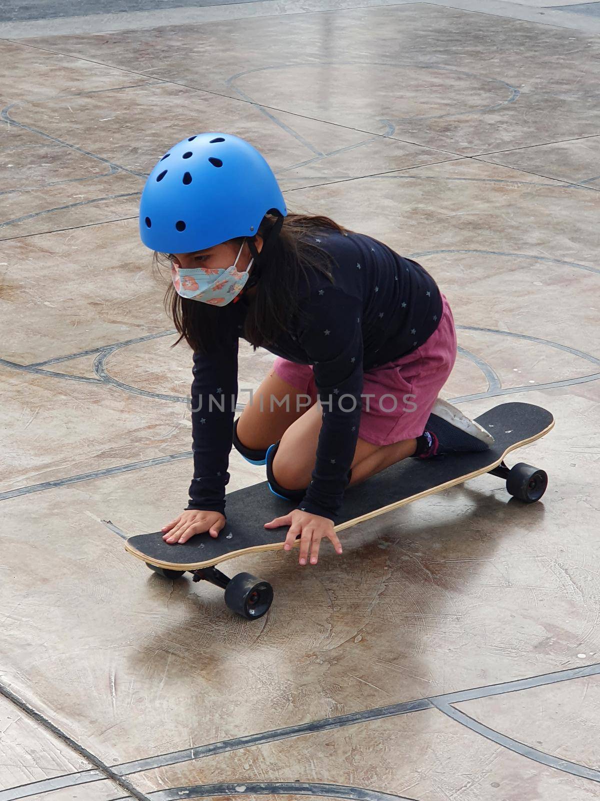 Beautiful skater girl riding on her longboard in the city