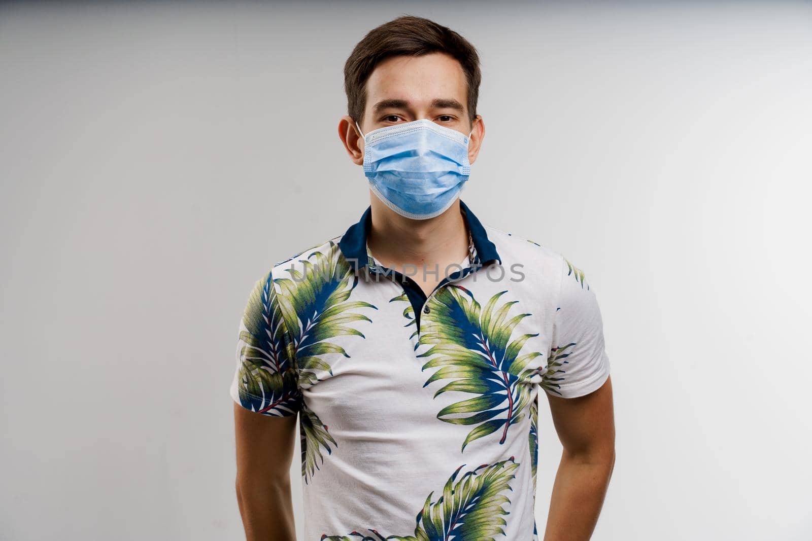Coronavirus covid-19 quarantine concept. Man in blue medical mask is sick covid virus isolated on white background. by Rabizo