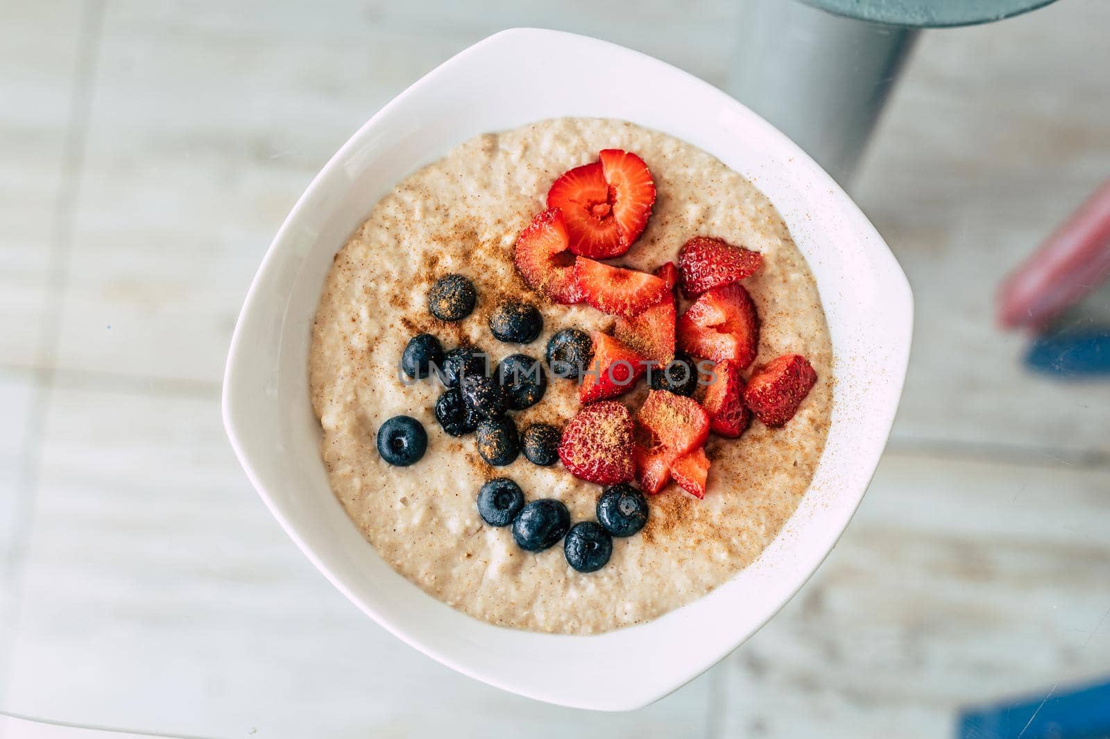 Homemade oatmeal with blueberries and strawberries in a bowl. Healthy breakfast. Top view. by Peruphotoart