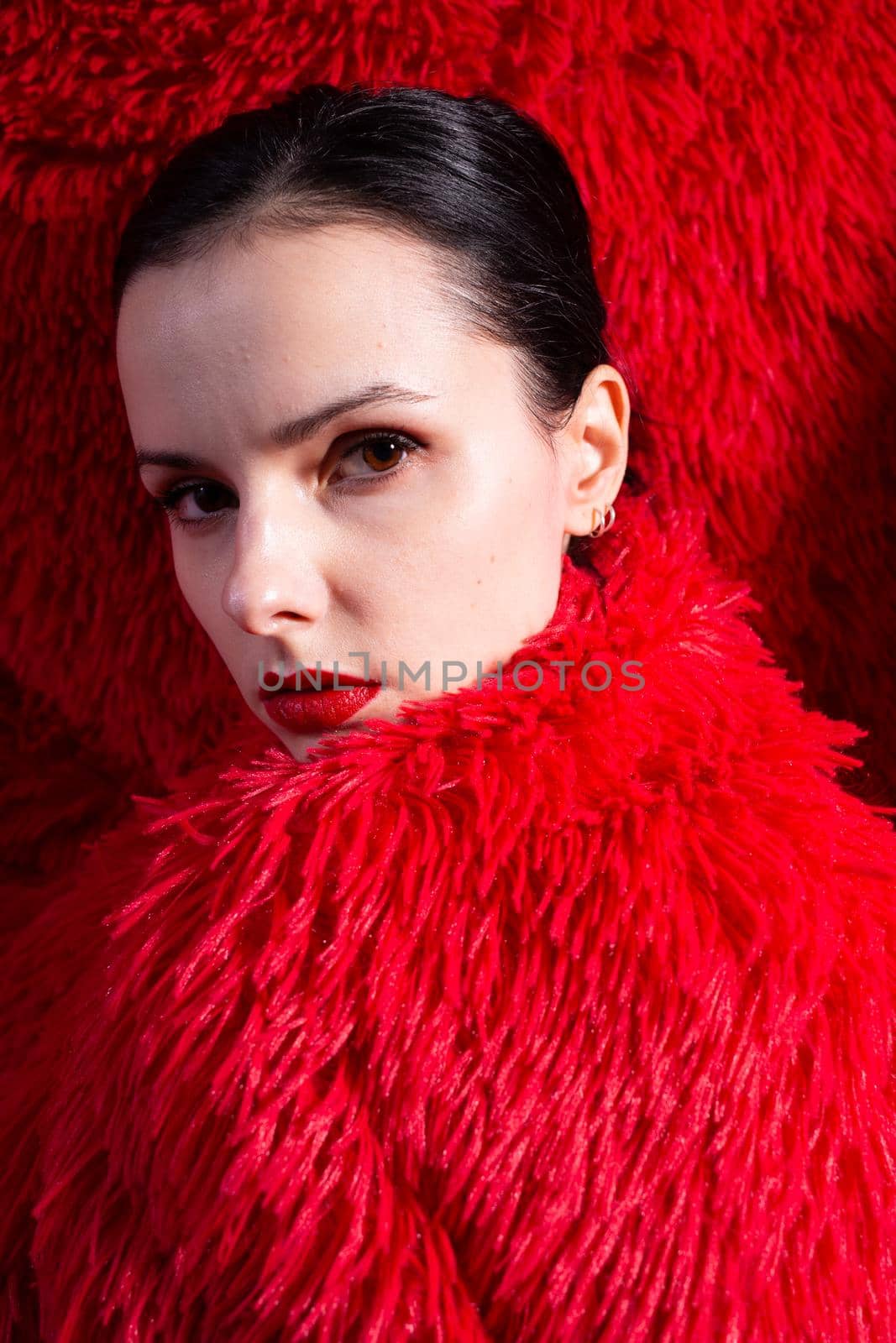 woman with red lips in red fluffy clothes, red fluffy background. High quality photo