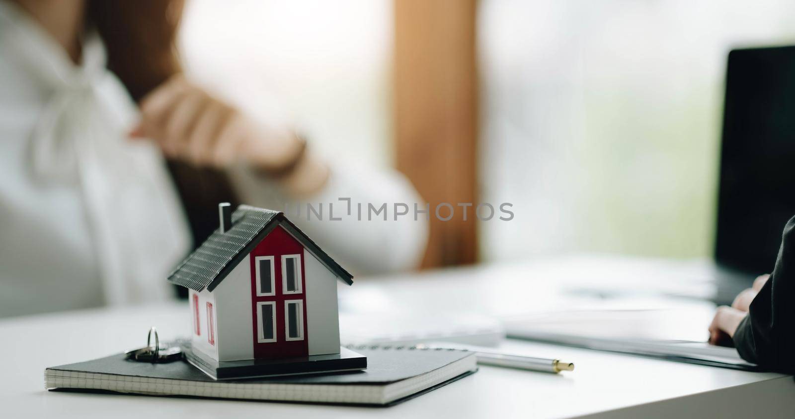 House model with real estate agent and customer discussing for contract to buy house, insurance or loan real estate background.