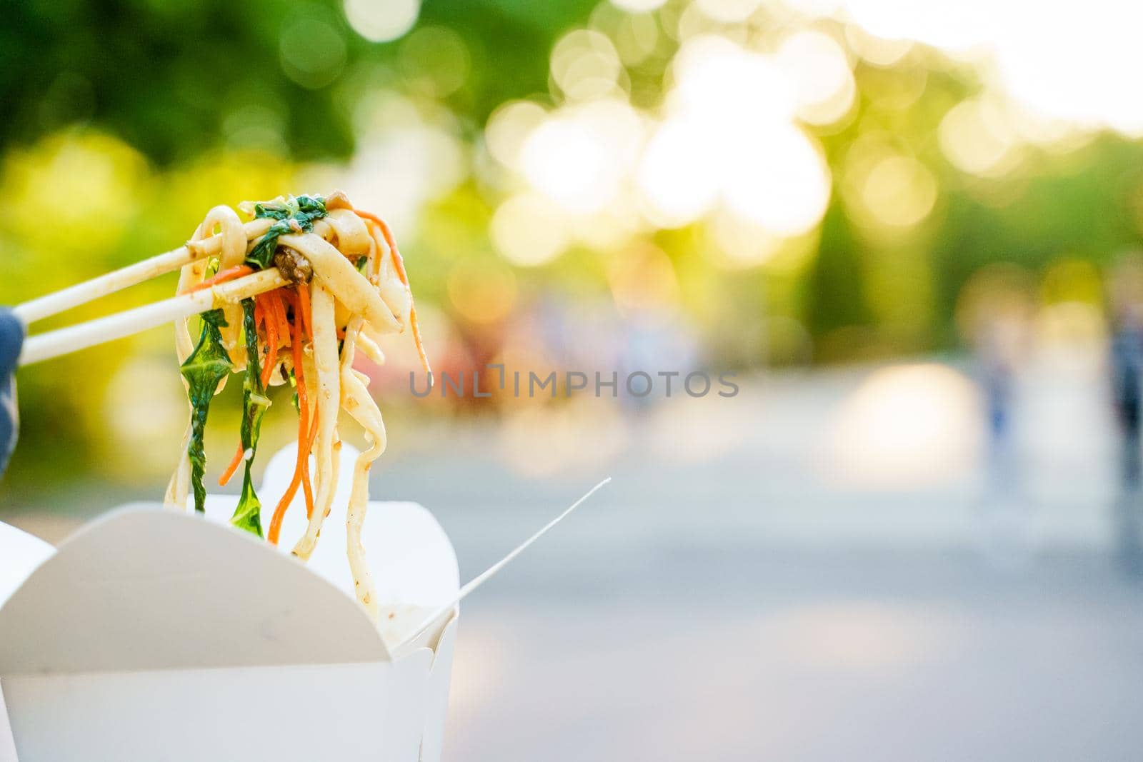 Closeup udon noddles on blurred background gets out of the white box. Advertise for Japanese restaurant delivery. Stay at home and eat udon noodles.