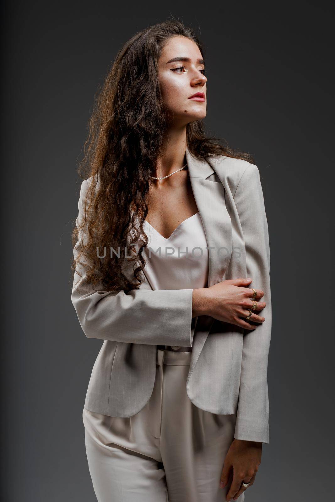 Gorgeous young female in classic suit in photostudio. Fashion, elegant and sexy professional model in studio.
