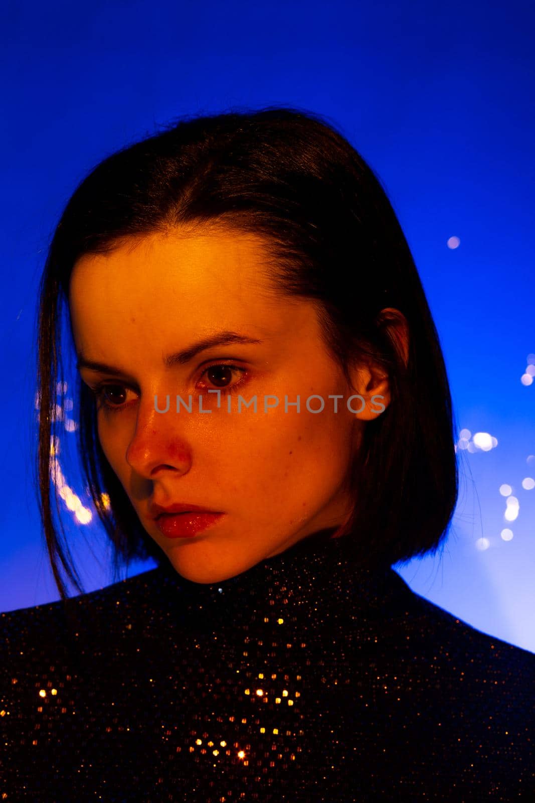 beautiful brunette woman with orange light on her face by shilovskaya