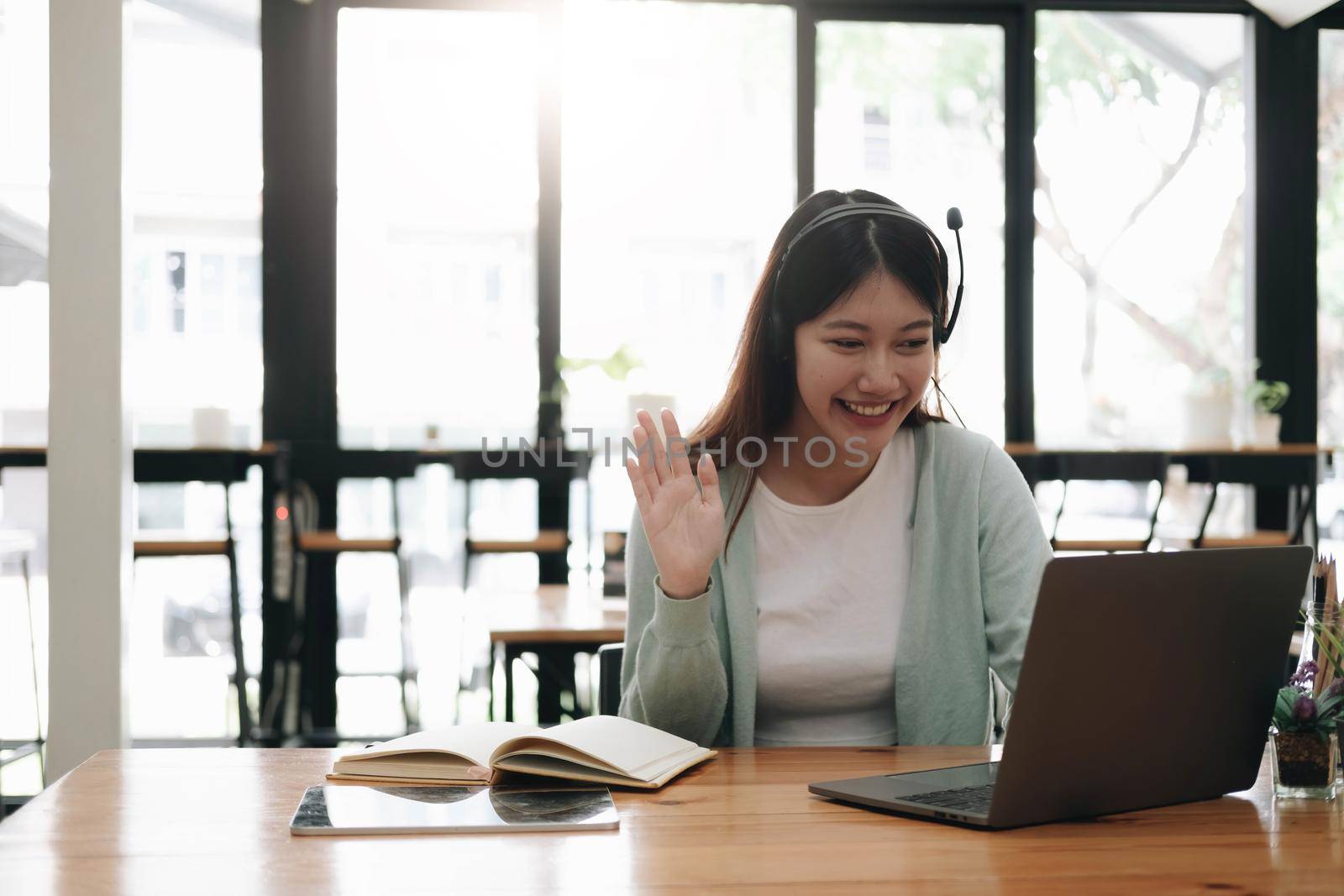 Asian woman wearing headphones study online watching webinar podcast on laptop listening learning education course conference calling, elearning concept. by wichayada